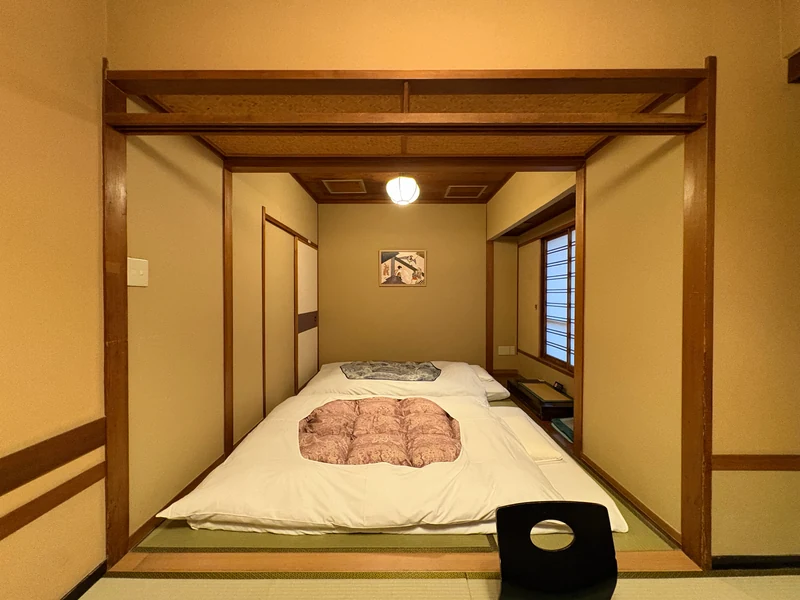 座卓の奥に布団を整えた江戸屋の和室