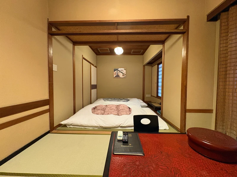 座卓の奥に布団を整えた江戸屋の和室