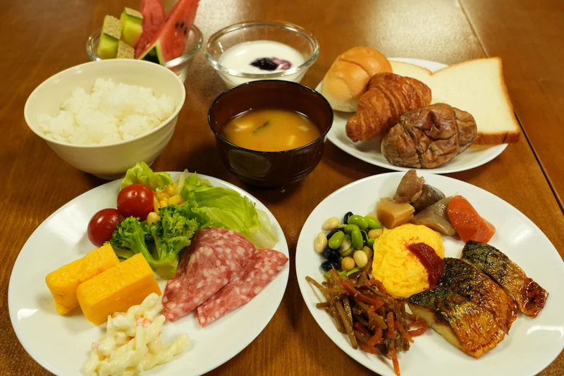 A breakfast selection with rice, bread, grilled fish and salad