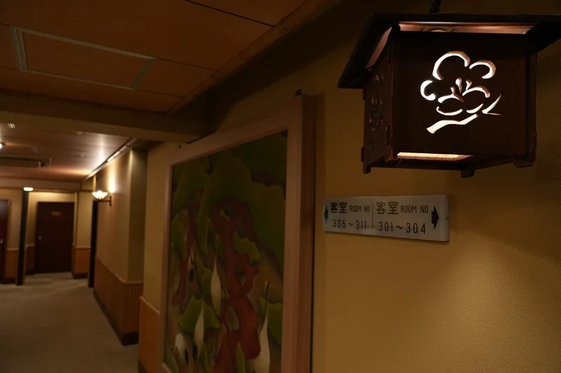 江戸屋の紋を透かした灯りと客室へ続く廊下