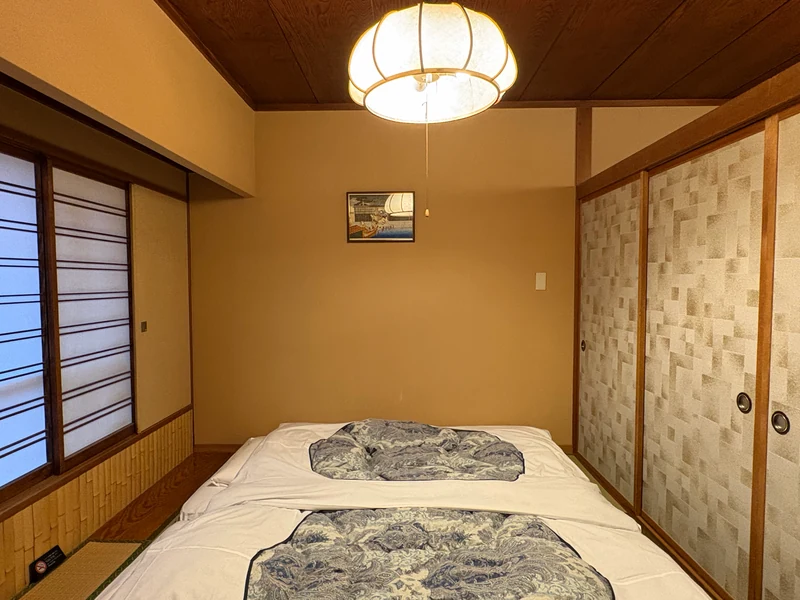 障子と襖に囲まれた江戸屋の和室に敷かれた布団