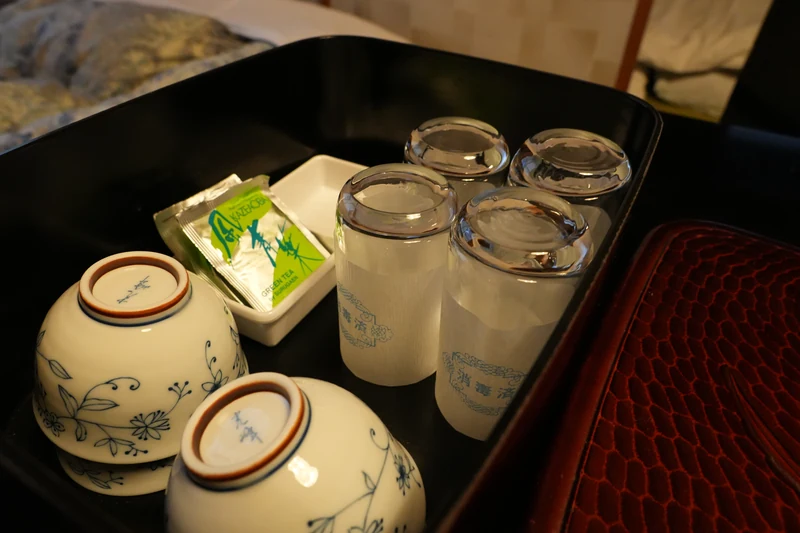 客室の茶器入れに並ぶ湯のみとグラス、緑茶